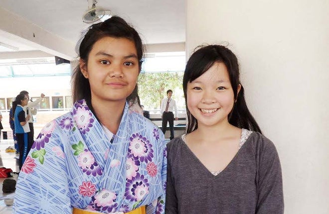 中学の修学旅行で訪れたタイで、 着付けをした現地の学生と一緒に。